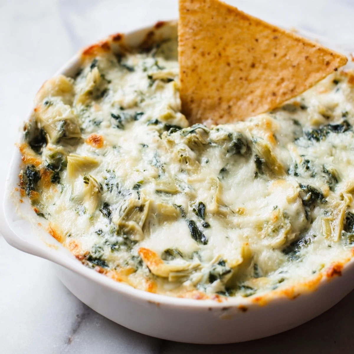 Hot Cheesy Spinach Artichoke Dip with Tortilla Chips is ready for a game day party.