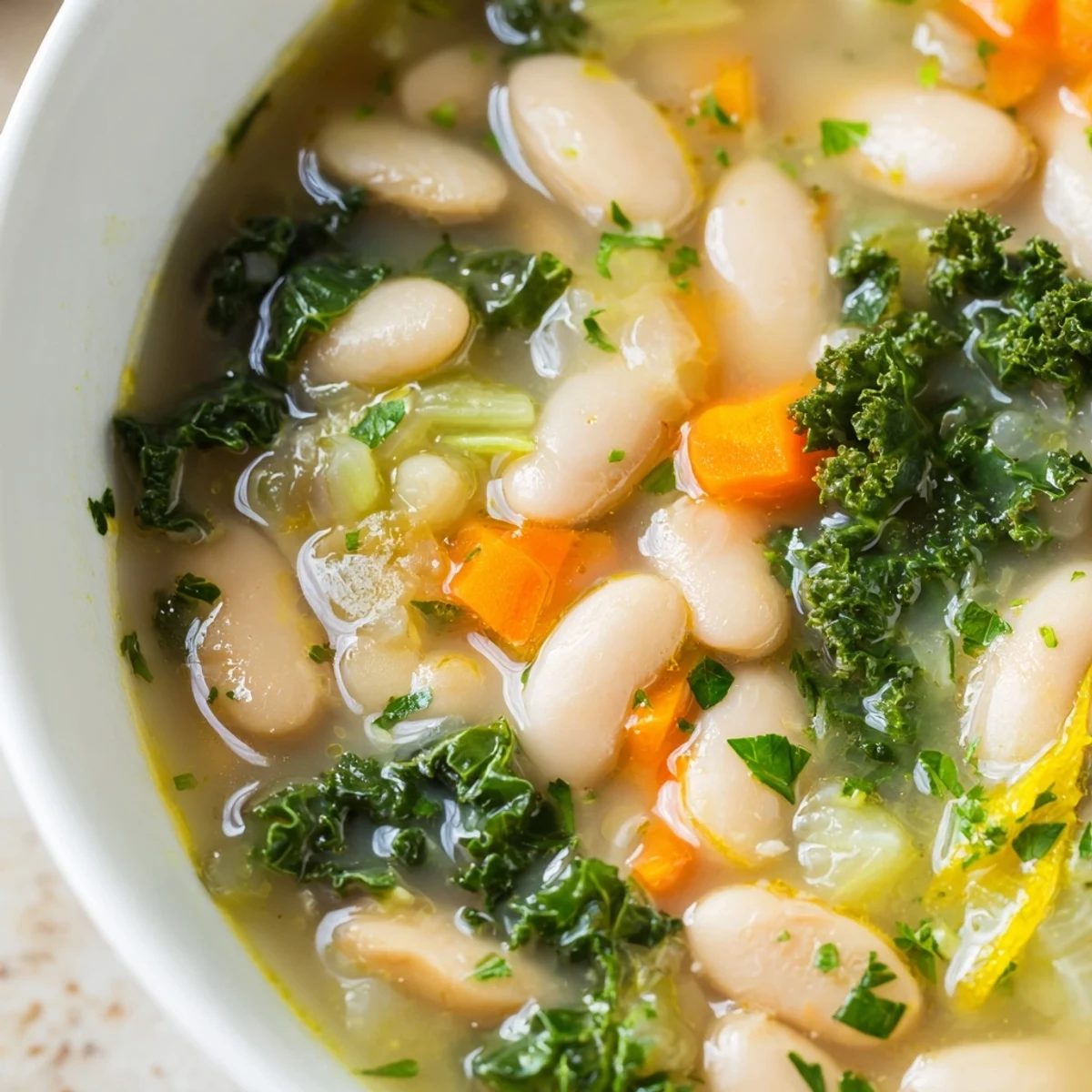 Homemade White Bean and Kale Soup with Lemon Zest served steaming hot from a rustic pot, garnished with fresh parsley.