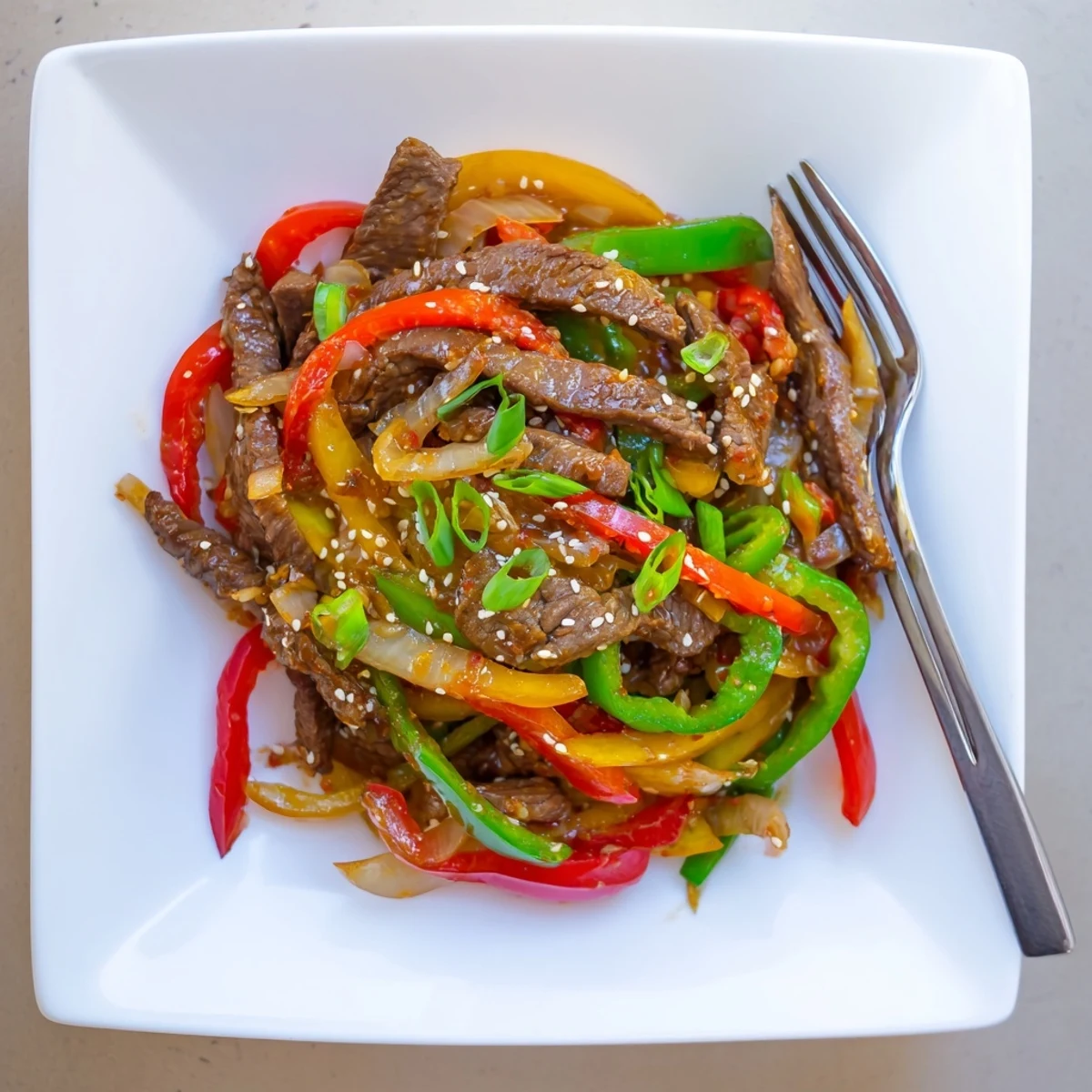 Vibrant, tender beef strips and crisp bell peppers tossed in a bold, spicy garlic sauce in this Spicy Beef and Pepper Stir Fry.