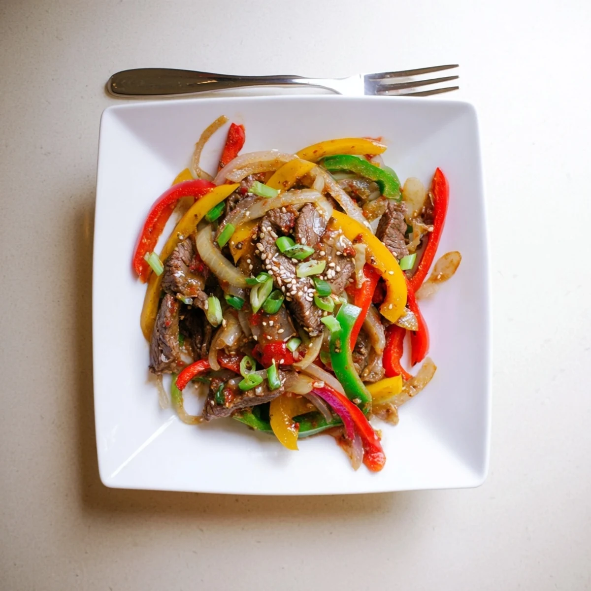 A sizzling wok fills with colorful bell peppers and savory beef, showcasing a quick, 25-minute Spicy Beef and Pepper Stir Fry.