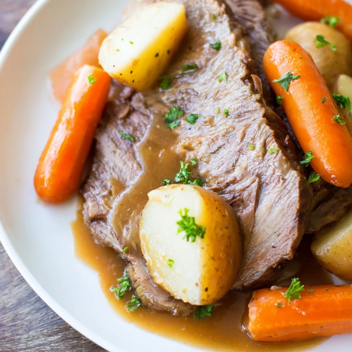 Savory slow cooker pot roast with shredded beef, ladle of gravy, and roasted vegetables on a dinner plate.