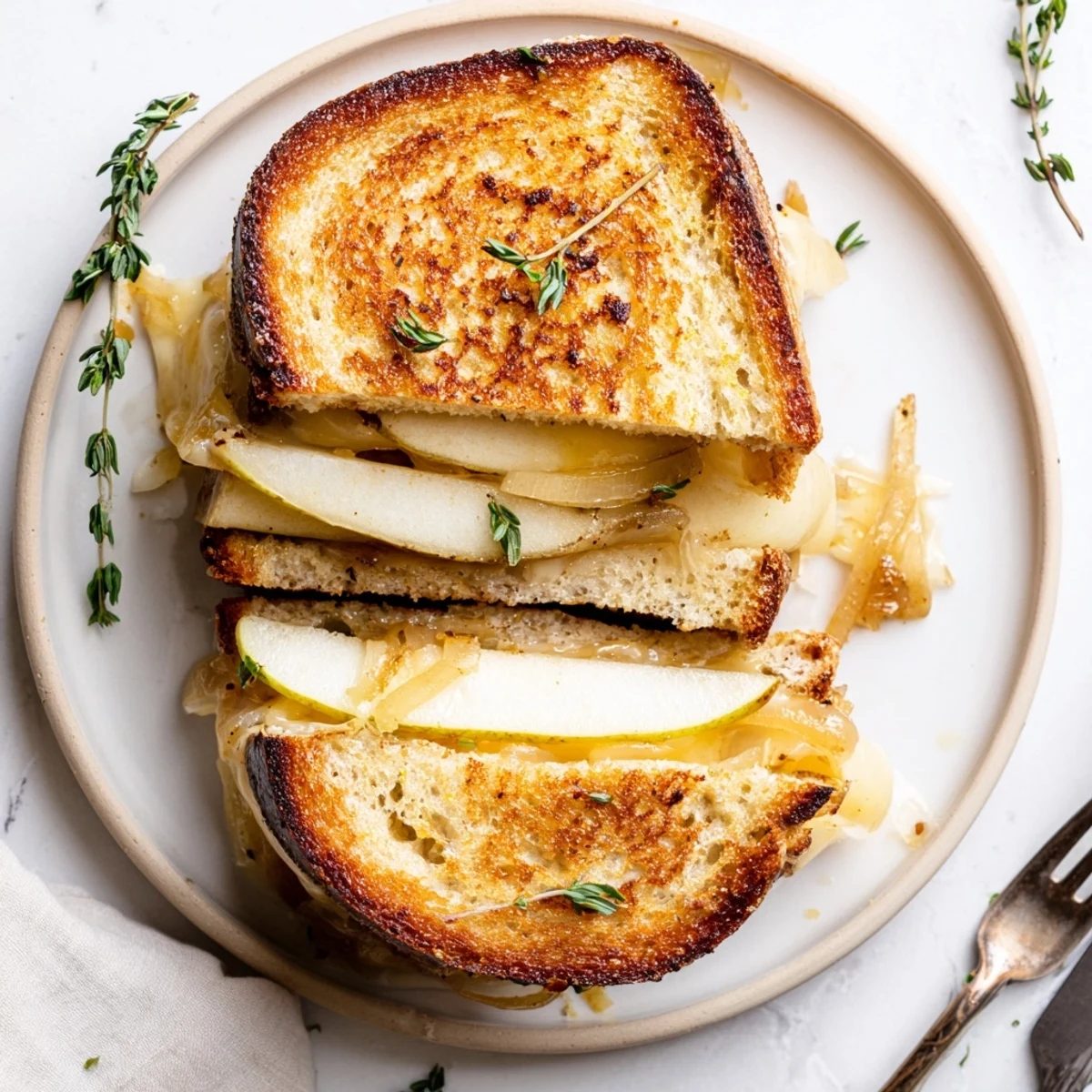The warm Pear, Apple & Grilled Cheese with Caramelized Onions features melted cheddar and golden sourdough bread. 