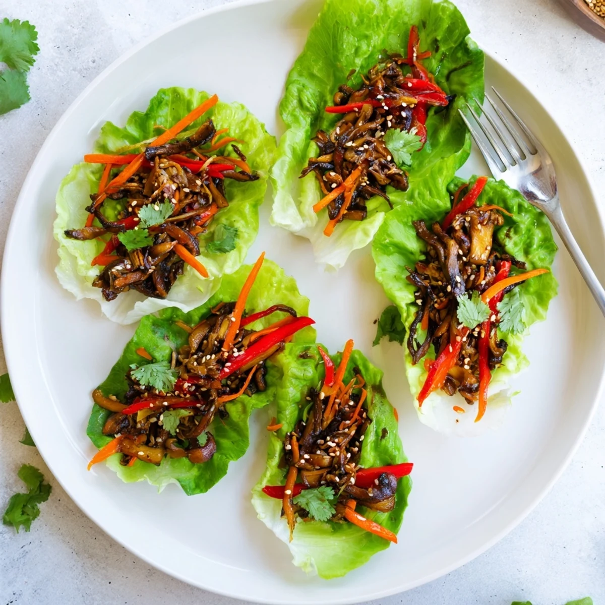 Overhead view of Shiitake Mushroom Lettuce Wraps in butter lettuce cups, showing colorful vegetables and glossy savory sauce.