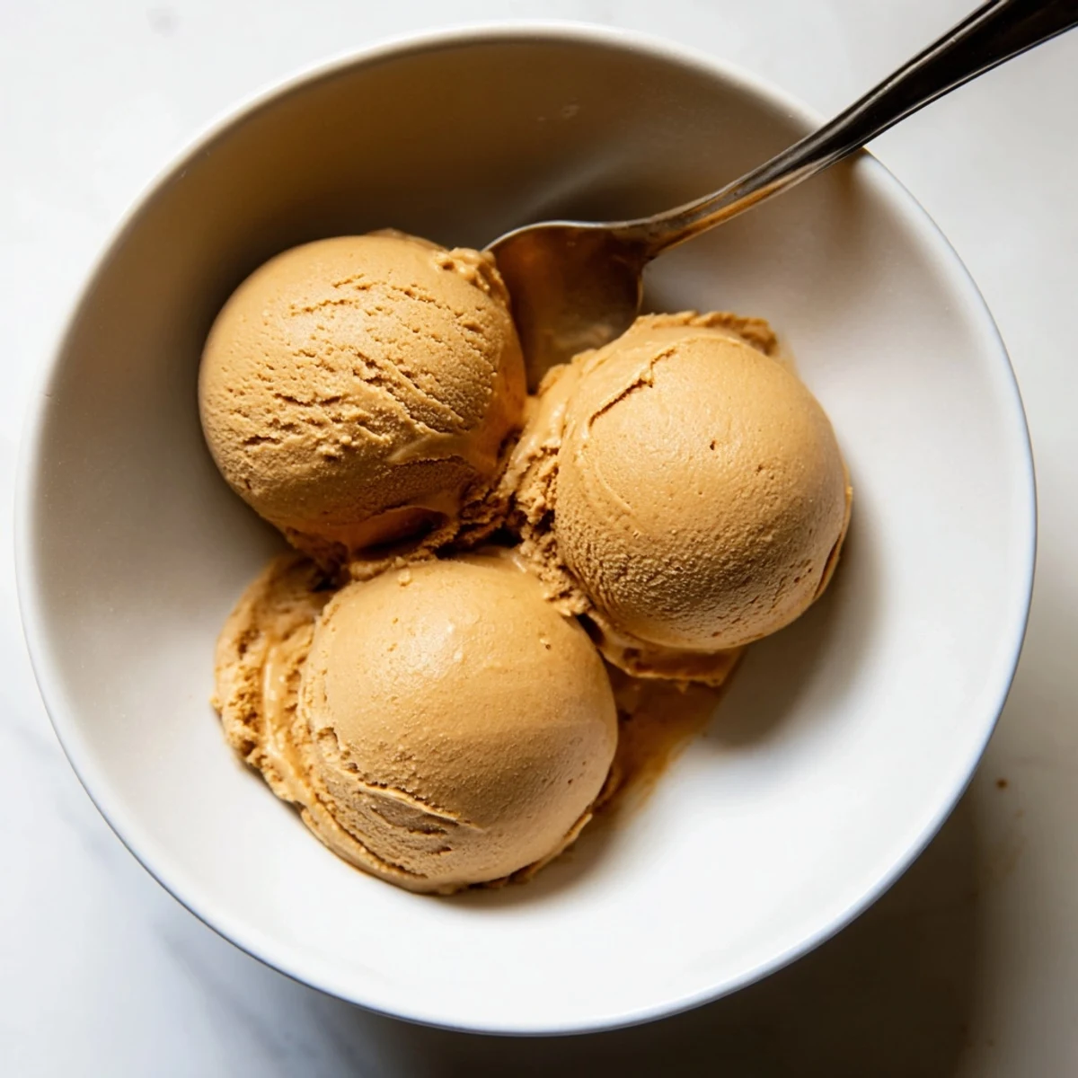 Scoops of Hojicha Ice Cream served in a ceramic dish, emphasizing the smooth texture and roasted aroma.
