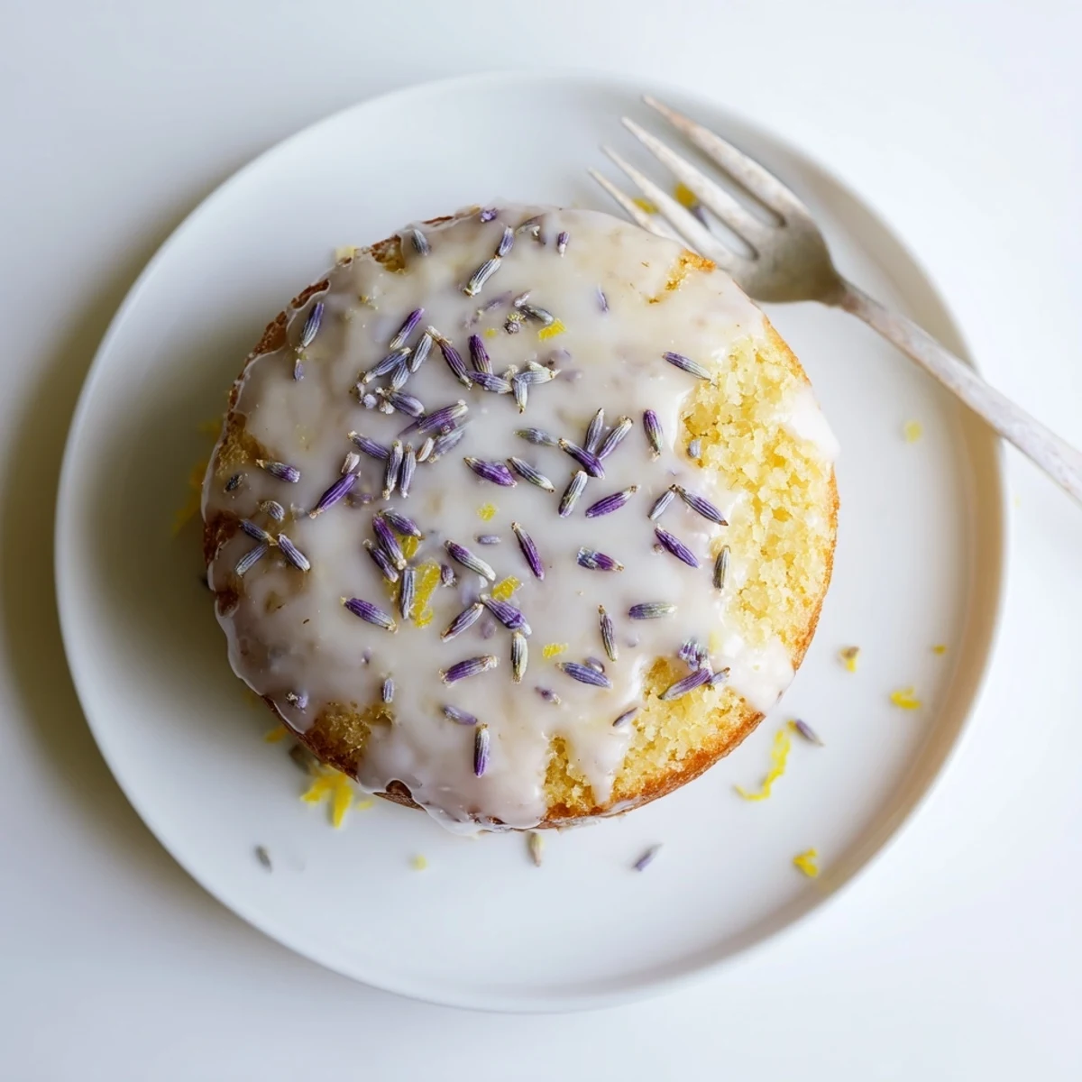 Glazed Lemon Lavender Cake slice drizzled with icing, served on a white plate for afternoon tea.