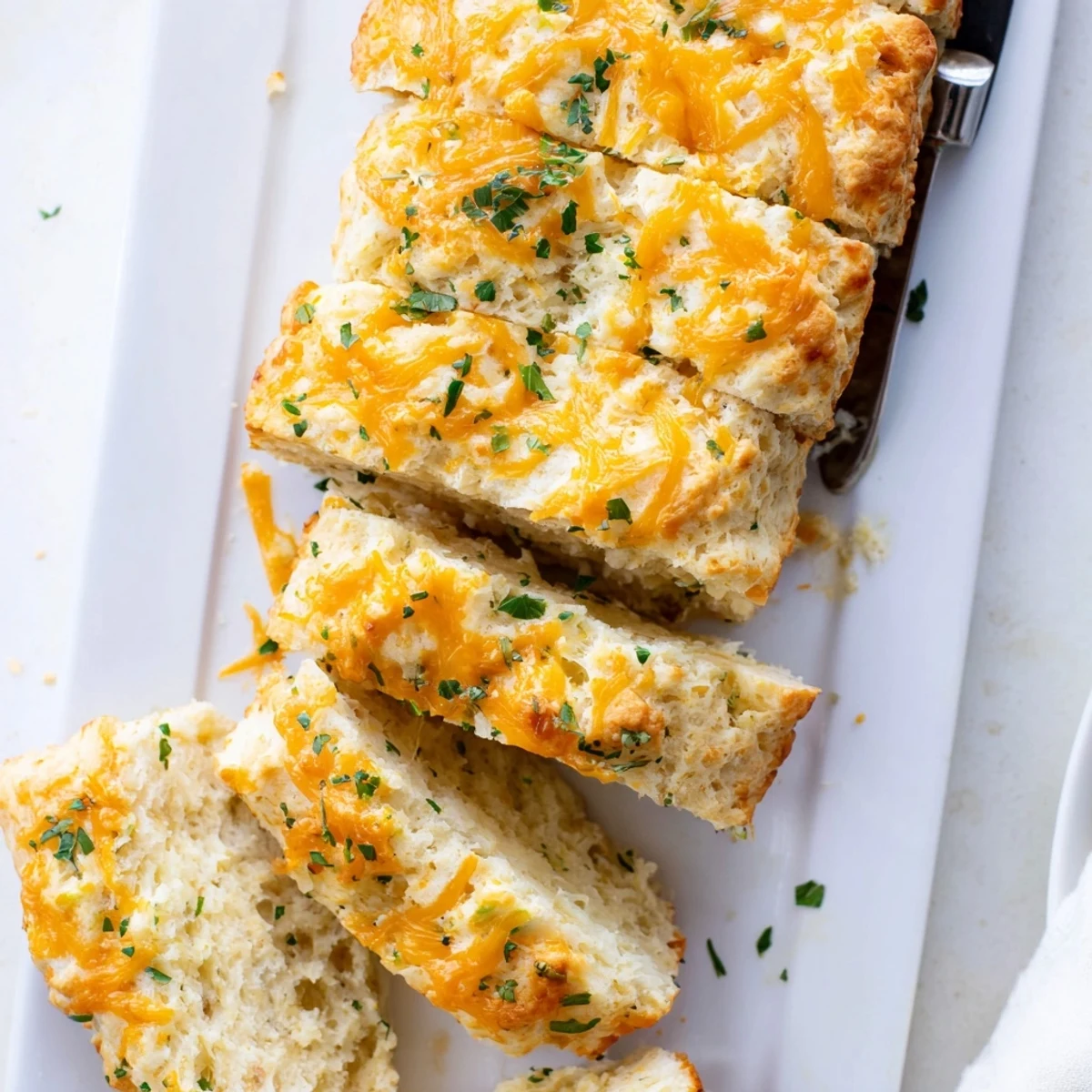 Golden-brown Red Lobsters Cheddar Bay Biscuit Loaf fresh from the oven, brushed with savory garlic butter and parsley topping.