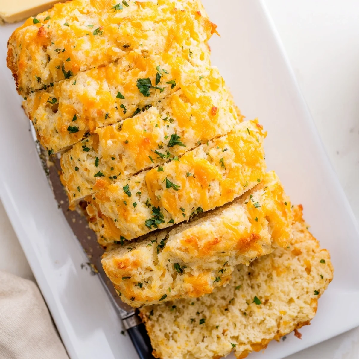 Serving suggestion for Red Lobsters Cheddar Bay Biscuit Loaf beside a steaming bowl of seafood chowder for dipping.