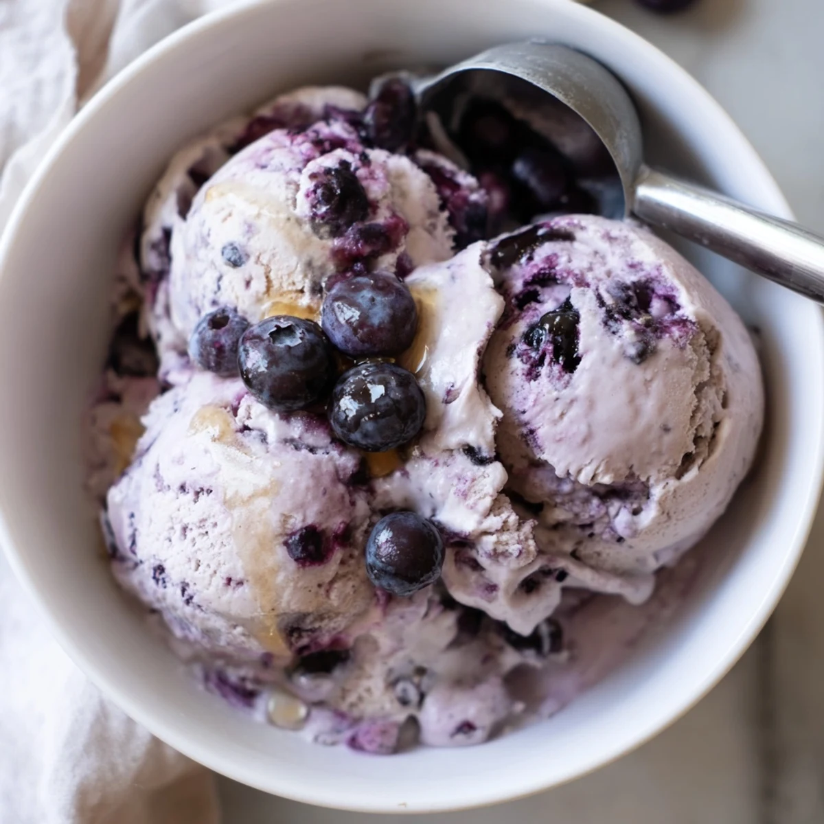 The vibrant purple hue of homemade Blueberry Cottage Cheese Ice Cream shows its rich fruit content, ready to serve.  