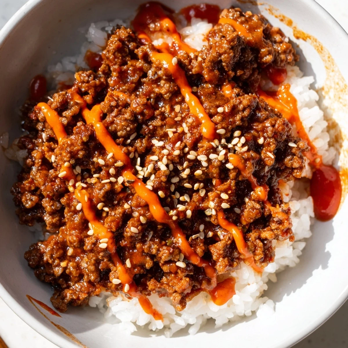 Over steamed rice, the Korean Beef Bowl with Spicy Mayo showcases glossy beef, sesame seeds, and bright red cabbage garnishes.