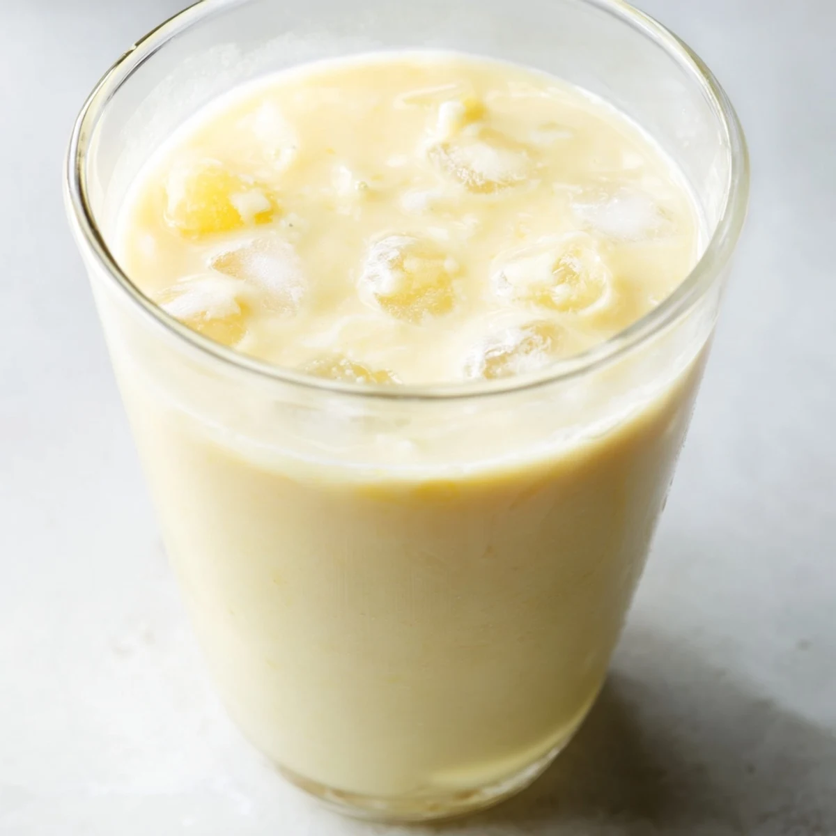 Creamy durian smoothie blended with banana and coconut milk in tall glasses