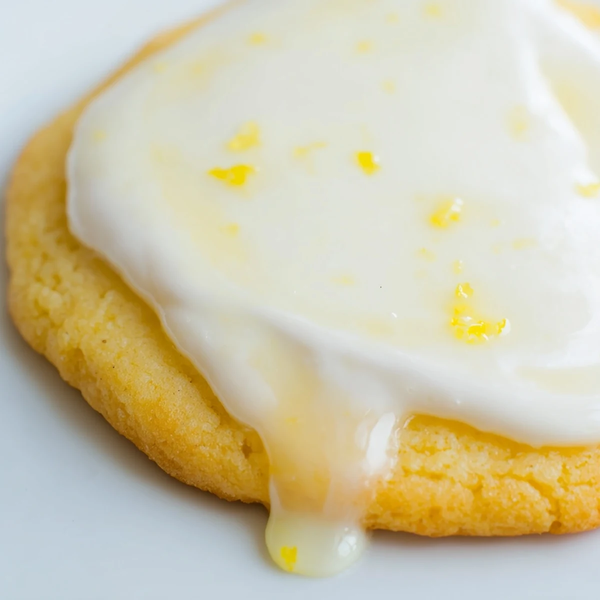 Soft buttery lemon cookies topped with creamy zesty frosting arranged on a decorative serving platter