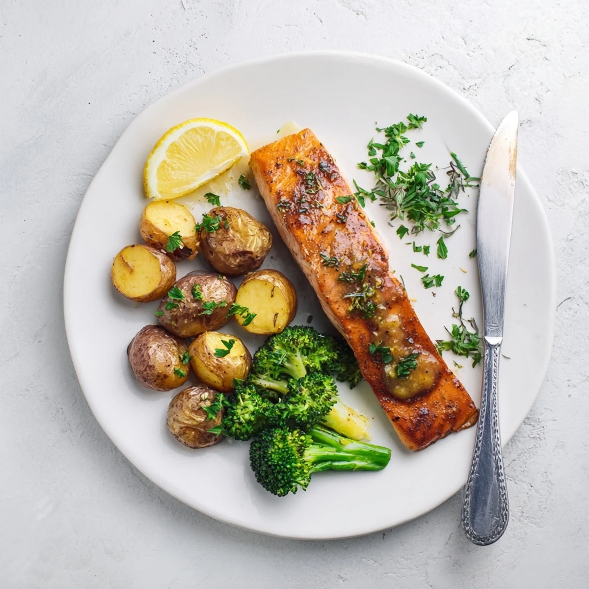 Golden pan-seared salmon drizzled with lemon butter sauce alongside roasted potatoes and broccoli