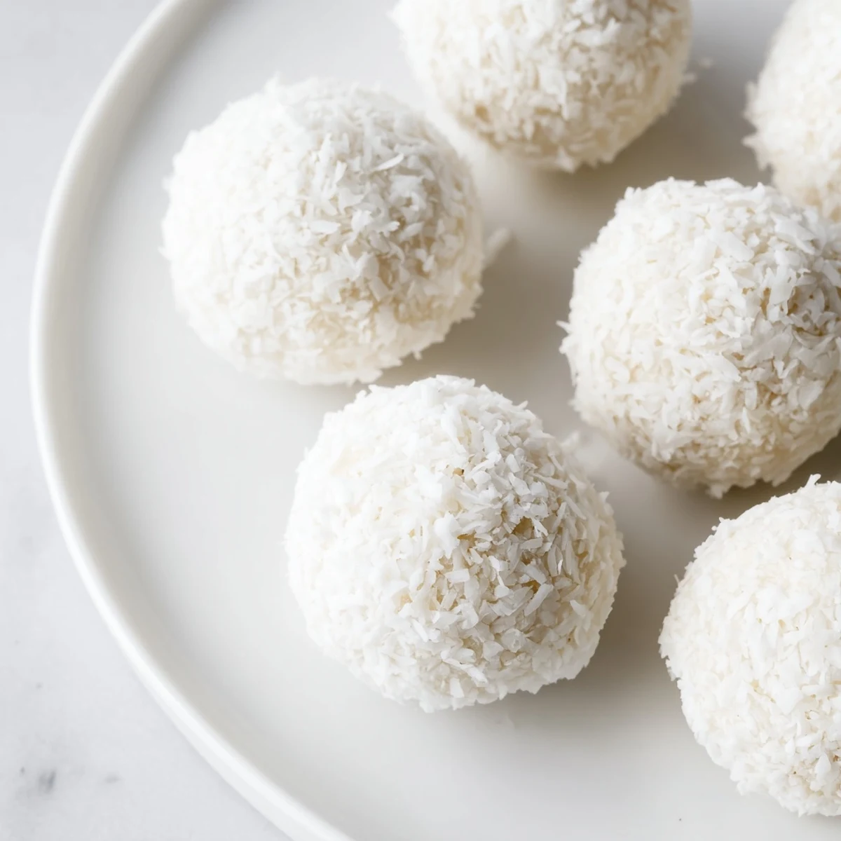 Snowy white Easter bunny coconut tails arranged on parchment paper for spring dessert display