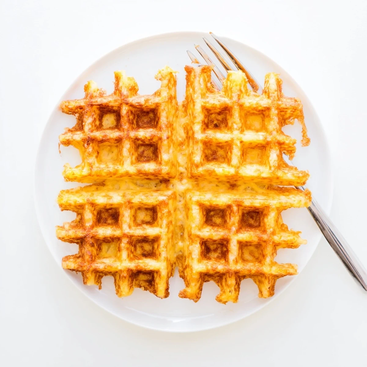 Perfectly golden waffle iron hashbrowns showing extra crispy texture and deep waffle indentations