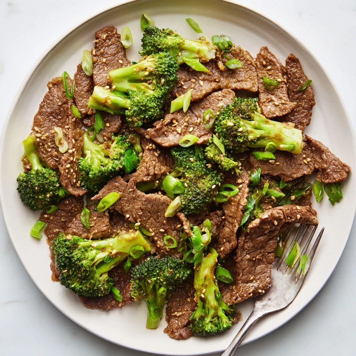Tender Crock Pot Beef and Broccoli served over steamed white rice with sesame garnish