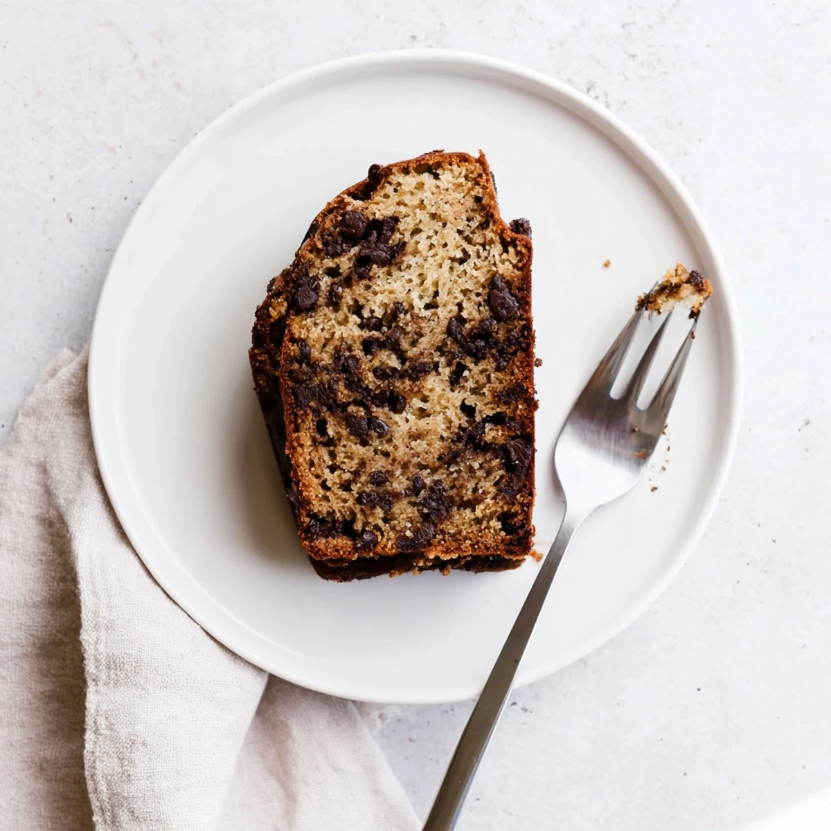 Moist chocolate espresso banana bread loaf studded with melty chocolate chips on a wooden board