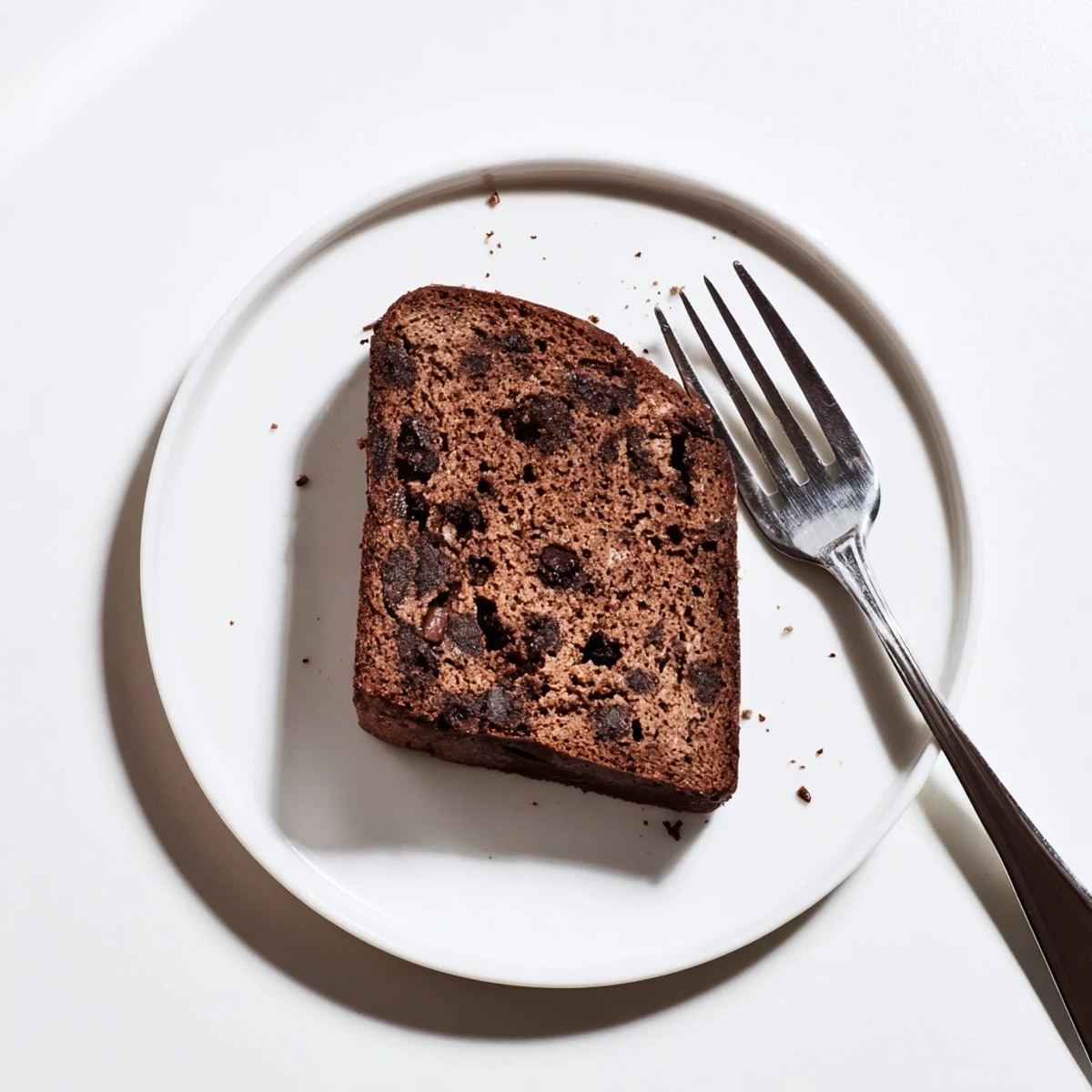 Freshly baked chocolate espresso banana bread cooling on wire rack with coffee mug nearby