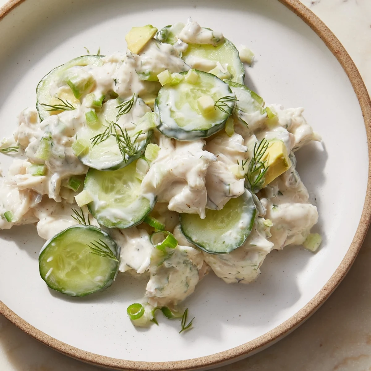 Cucumber salad with crab meat in creamy dressing topped with fresh dill garnish