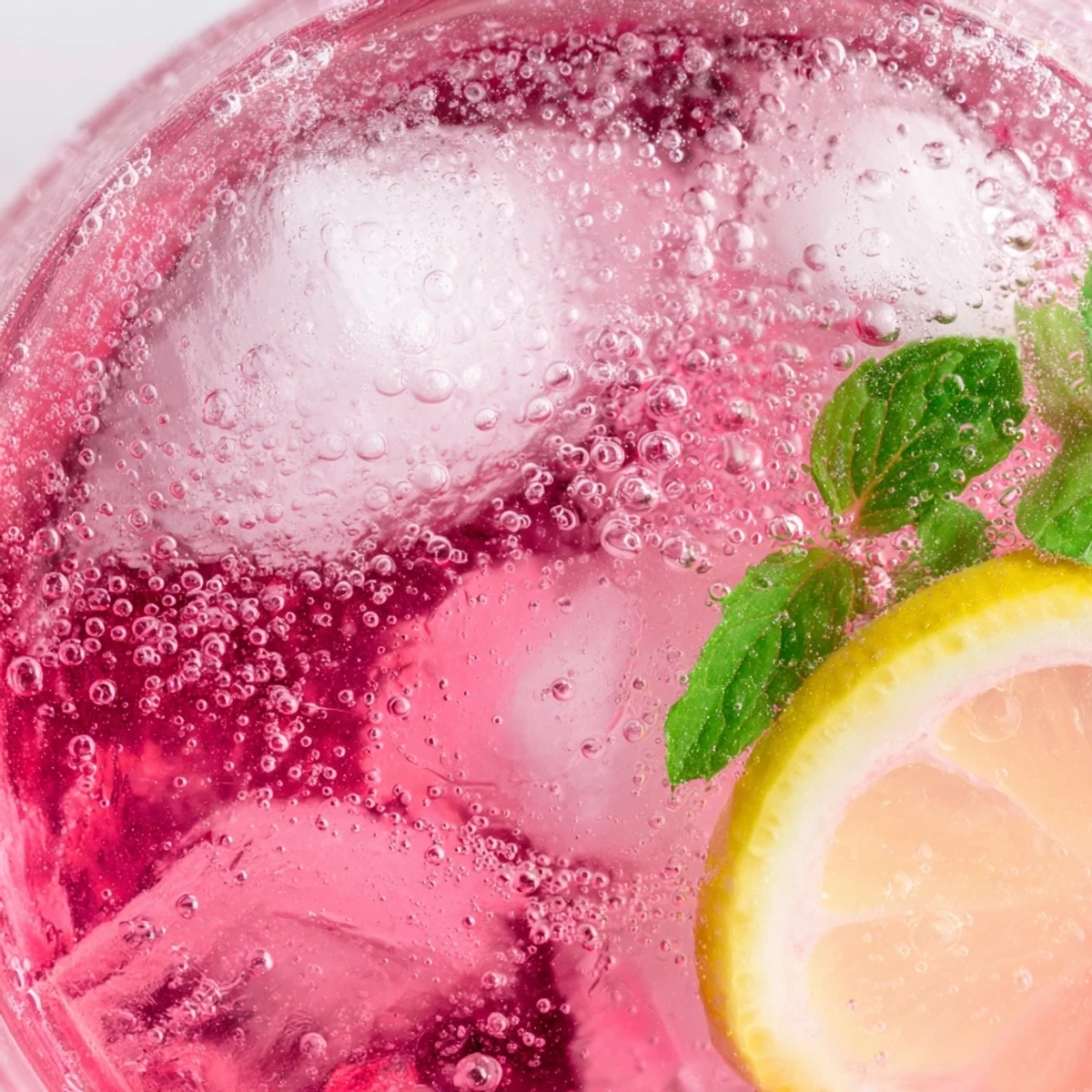 Sparkling honey lemon pink soda in tall glasses with bright citrus wedges