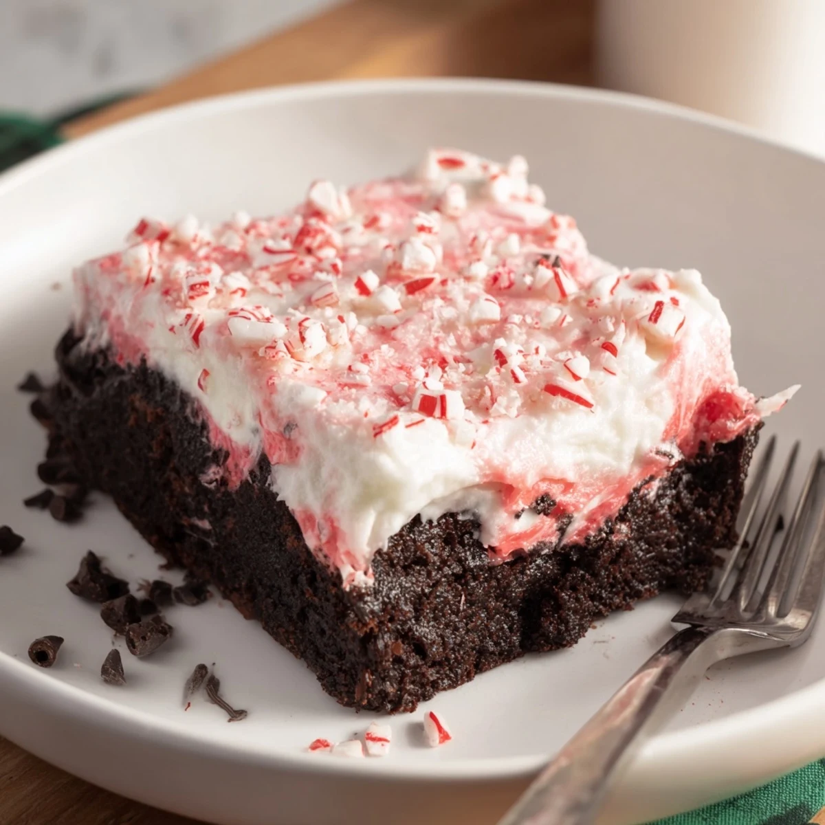 Pan of freshly poked Peppermint Poke Cake cooling, pudding filling seeping