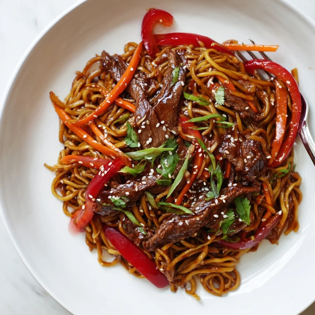Bowl of Sticky Beef Noodles with tender beef strips and crunchy peppers