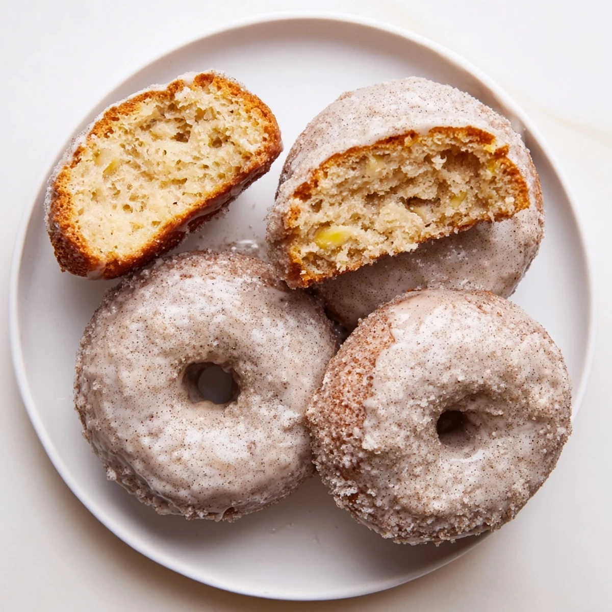 Warm Banana Donuts glazed and stacked on a wire rack, steaming.