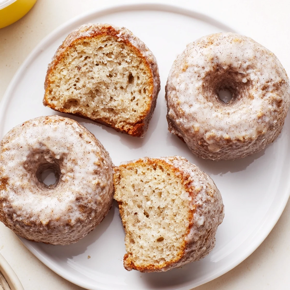 Golden Banana Donuts dusted with powdered sugar, served beside coffee mug.