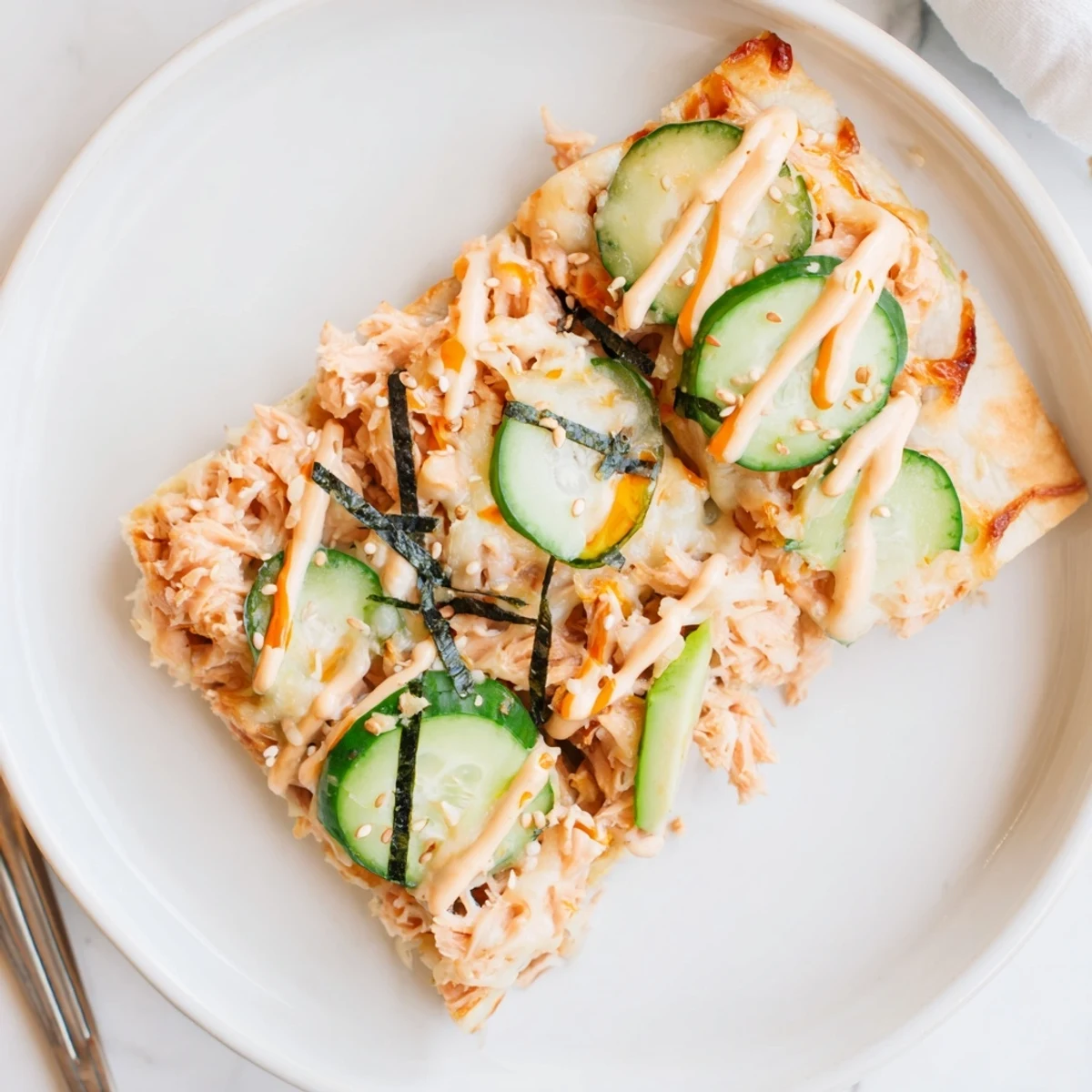 Crisp golden edges and cucumber on Salmon Sushi Bake Flatbread Pizza With Spicy Drizzle