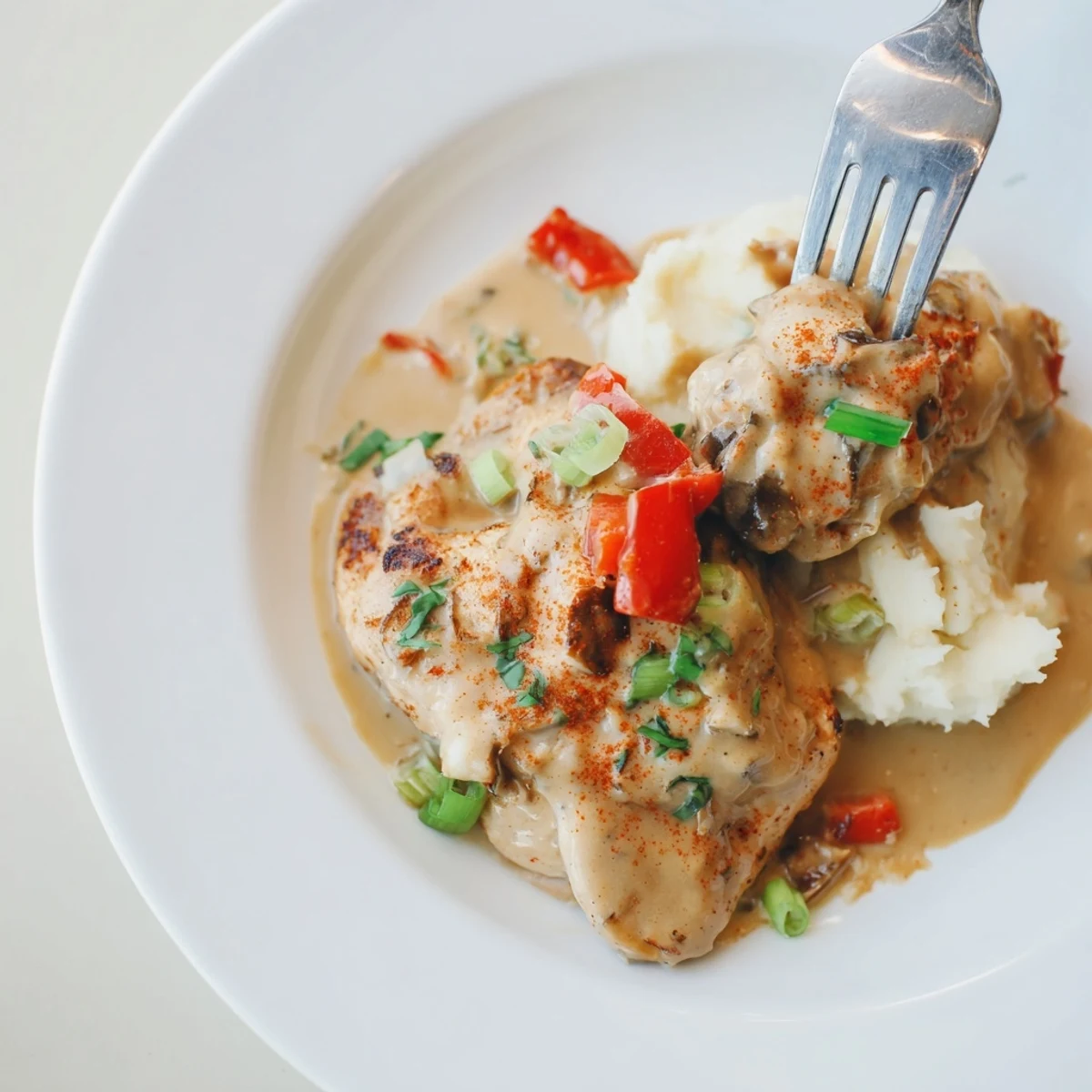 Mississippi Mud Chicken glazed in smoky cream sauce, resting over mashed potatoes