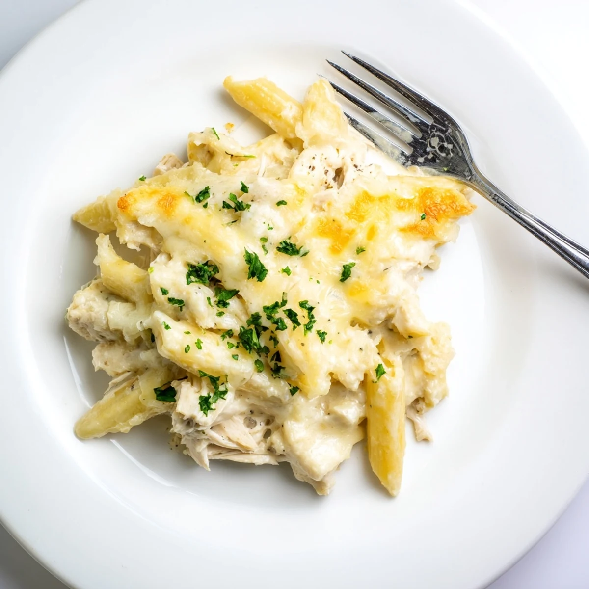 Crisp golden edges surround Creamy Chicken Alfredo Bake With Mozzarella Crust in casserole