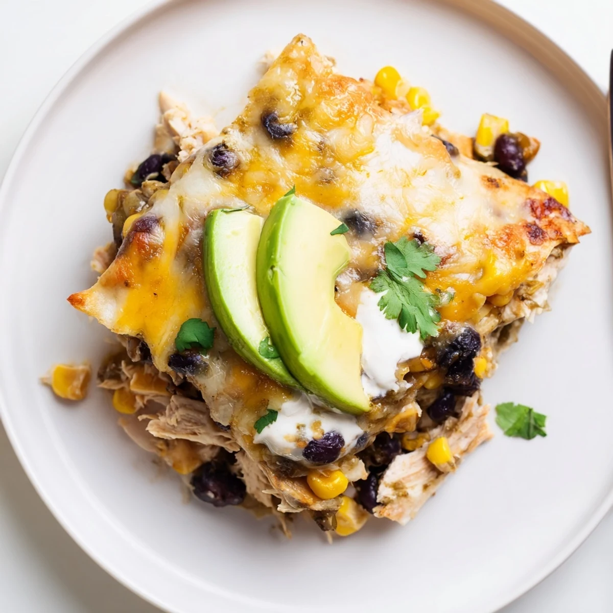 A warm Salsa Verde Chicken Casserole layered with tortillas, corn, black beans  