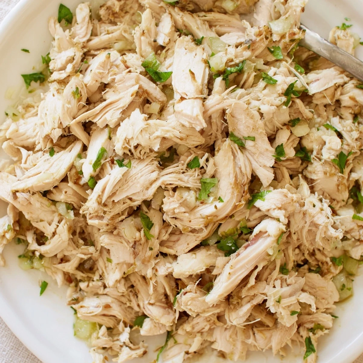 Shredded Slow Cooker Cilantro Lime Chicken piled in warm tortillas with lime wedges