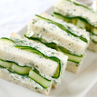 Delicate layers of crisp English cucumber slices and creamy herbed cheese spread between soft bread, ready to serve at room temperature.