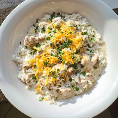 Comforting one-pan creamy smothered chicken and rice with melted cheddar topping
