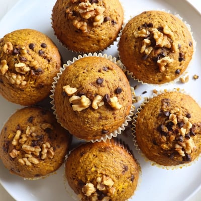 Freshly baked butternut squash banana muffins cooling on a wire rack with steam rising